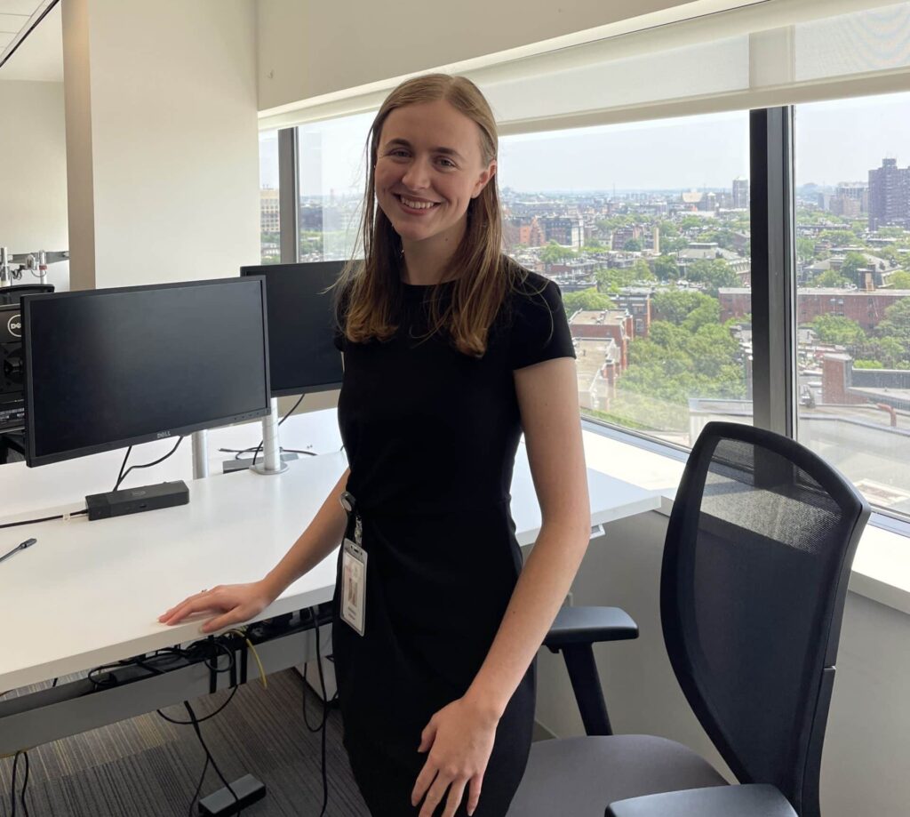 Berkeley Rebman standing at her Wayfair office desk